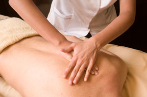 Sanfte Streichungen entlang der Wirbelsäule während einer Breuss-Massage
